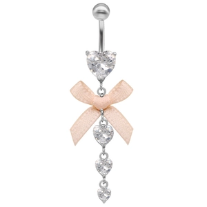 Détail d'un piercing de nombril argenté avec nœud rose et zircons en forme de cœur
