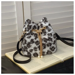 Detail of leopard print plush bucket bag with golden chain and large pearl accents