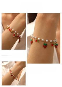 Detail view of pearl bracelet featuring colorful strawberry, cherry, and watermelon charms