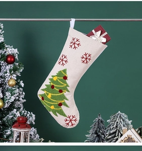 Détail de la chaussette de Noël en lin beige avec sapin brodé et flocons rouges