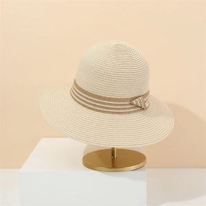 Elegant wide-brim straw sun hat for women with striped bow ribbon on a display stand