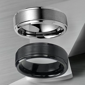 Detailed close-up of silver and black titanium steel rings with brushed metal texture