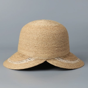 Macro shot of fine raffia straw texture and decorative stitching on wide brim sun hat