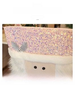 Close-up of pink sequined Christmas chair cover with white faux fur and holiday decor