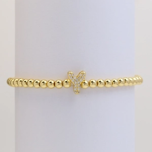 Macro view of gold beaded elastic bracelet with a micro-pave zircon letter Y pendant
