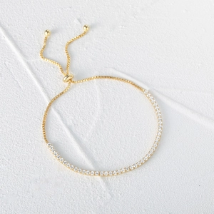 Close-up of gold adjustable tennis bracelet with sparkling zircons and box chain detail