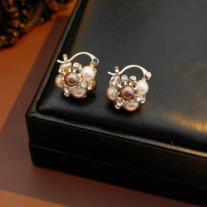 Détails de boucles d'oreilles vintage avec perles et strass sur une boîte à bijoux en cuir noir