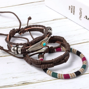 Macro detail of 4-piece vintage leather bracelets with silver feather and beads