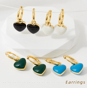 Detail showing colorful heart drop earrings in black, white, green and blue enamel finish