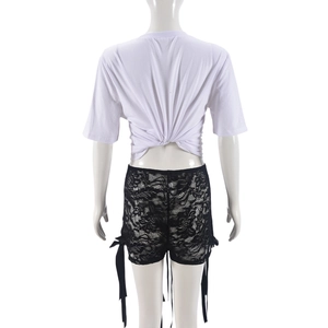 Détail du t-shirt blanc avec nœud au dos et short en dentelle noire avec ruban décoratif