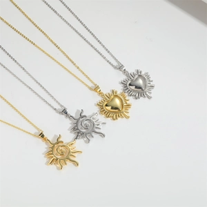 Minimalist sun and heart pendant necklaces in gold and silver finish on light background