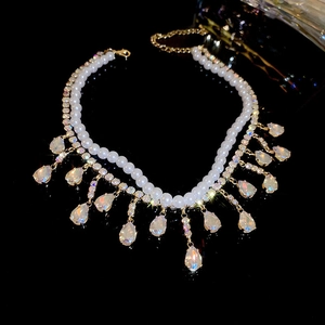 Macro shot of double-layer pearl necklace with rhinestone tassel and golden finish