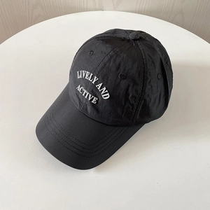 High-quality detail of a black nylon quick-dry baseball cap with white embroidery text.