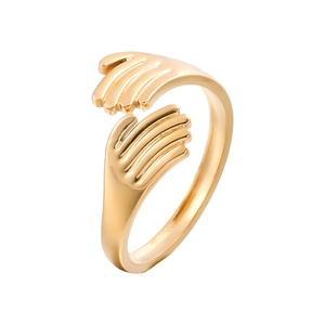 Detailed view of golden stainless steel hugging hands open ring with a polished finish