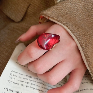 Détail d'une bague coeur en résine rouge sur main de mannequin au style vintage automne