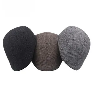 Detailed view of tweed flat caps in dark gray, brown, and light gray colors