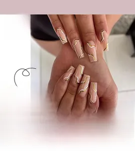 Detail of long coffin press-on nails with nude pink base and gold white wave patterns