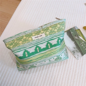 Detail of floral jacquard green cosmetic bag with zip and simple wish fabric label