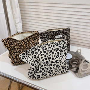 Three-piece leopard print canvas makeup bags with zippers shown in a stylish display
