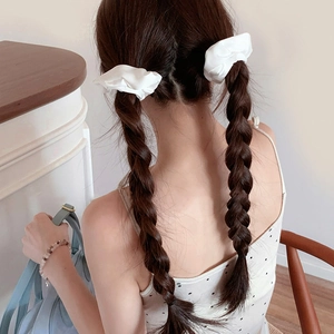 Pair of white satin scrunchies shown on double braids for a French vintage hairstyle