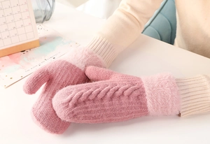 Detailed texture of pink knit gloves with plush cuffs worn in a cozy lifestyle setting