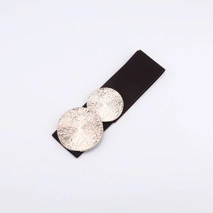 Close-up of elastic wide waist belt with golden sunburst texture round buckle on white background