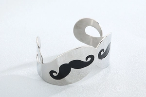 Detailed view of silver open cuff bracelet featuring black enamel mustache design pattern