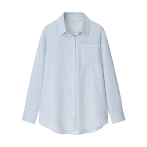 Close-up of white lace trim on cuffs and chest pocket of a blue striped shirt
