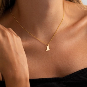 Gros plan d'un collier en acier inoxydable plaqué or 18K avec pendentif silhouette de chat