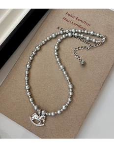 Close-up of elegant rocking horse pendant with pearls and sparkling crystal inlay