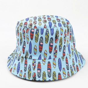 Détail d'un chapeau bob bleu clair avec imprimés planches de surf et motifs flamants