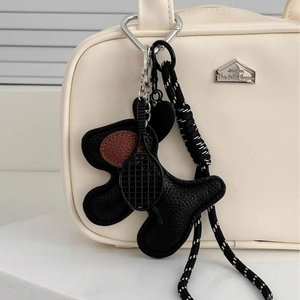 Fashionable black leather puppy bag charm with mini tennis racket and woven rope accent