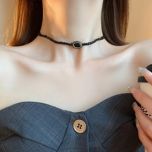 Close-up of gothic star necklace with black oval gemstone on a faux leather bead choker