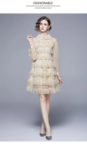 Broderie détaillée sur robe en dentelle beige avec col Claudine et jupon à volants