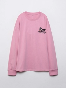 Detailansicht des rosa Langarm-T-Shirts mit schwarzem Drachendruck und XI XING LE Text
