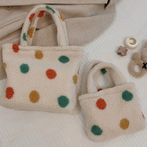 Detailed comparison of large and small plush polka dot handbags on soft quilted fabric
