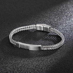 Detail of men's stainless steel woven bracelet with magnetic clasp and brushed metal finish