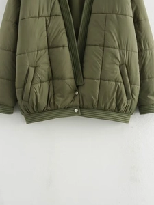 Detailansicht der olivgrünen Steppjacke mit Rippbündchen und silbernen Druckknöpfen