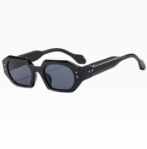 Detail view of irregular hexagonal sunglasses with black frames and silver rivets