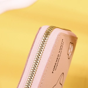 Close-up of pink PU leather wallet with gold zipper and cute cat pattern design