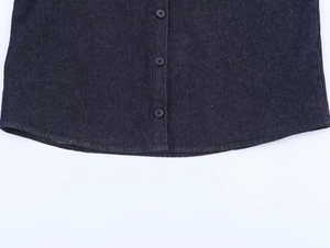 Detailed macro view of dark denim fabric with black buttons and fine contrast stitching