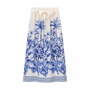 Women's summer white skirt with blue tropical leaf print and a decorative waist bow tie