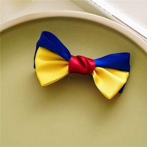 Détail du nœud papillon fait main en ruban de satin avec design tricolore rouge jaune bleu
