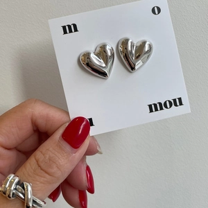 Close-up of minimalist heart-shaped 925 sterling silver studs with mirror polished finish