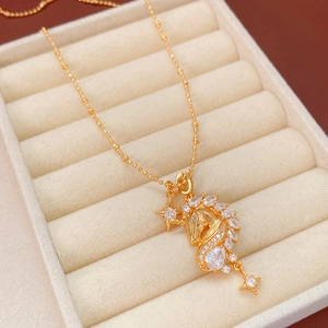Close-up of 18k gold plated unicorn necklace with sparkling cubic zirconia on beige velvet