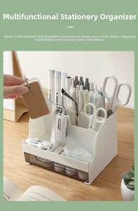 Detail view of a white multi-compartment desk organizer with a translucent drawer