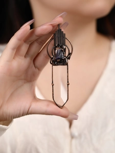 Detail of vintage copper sword pendant with raw amethyst stone and clear crystal point