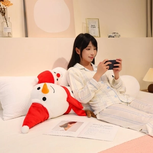 Detailed view of plush snowman long pillow with red hat and scarf on a cozy bed