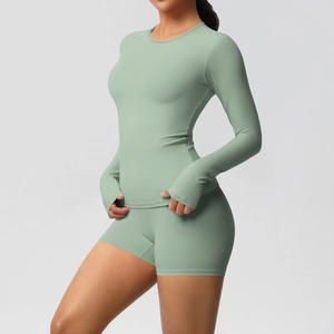 Detail of mint green yoga set featuring long sleeve top with thumbhole cuffs and high waist shorts