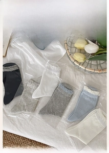 Detail of five-color mid-calf socks with bow patterns and ruffled cuffs in soft packaging